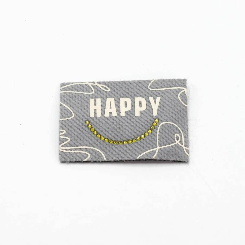 Aufbügelbares Webetikett Happy, hellgrau von Stoffe Hemmers